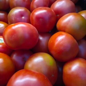 Tomates redondos rojos y maduros, listos para compra y consumo.