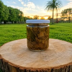 Frasco de conserva de vidrio con mezcla oscura sobre tronco de madera en jardín al atardecer